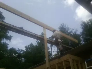 Carpenter setting a ridge beam over a new addition frame — Ice Dam Removal by Roofing Brothers in Ickesburg