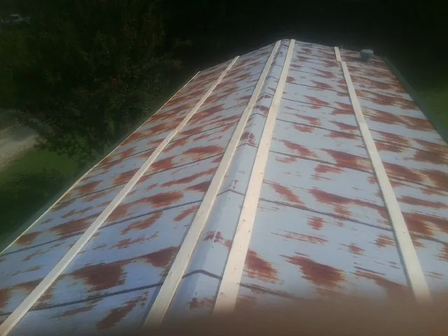 Rusted metal roof panels with new wood purlins before replacement — Storm Damage Roof Repair in Ickesburg by Roofing Brothers