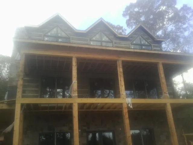 Dormers and porch framing on a large log home under construction — Roof Coating work by our crew in Ickesburg