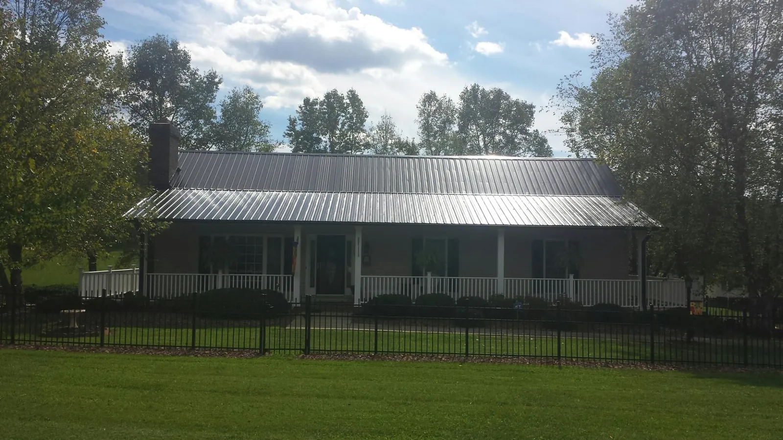 Gray metal roof on a brick ranch with a full width front porch — Gutter Guard Installation work by our crew in Ickesburg