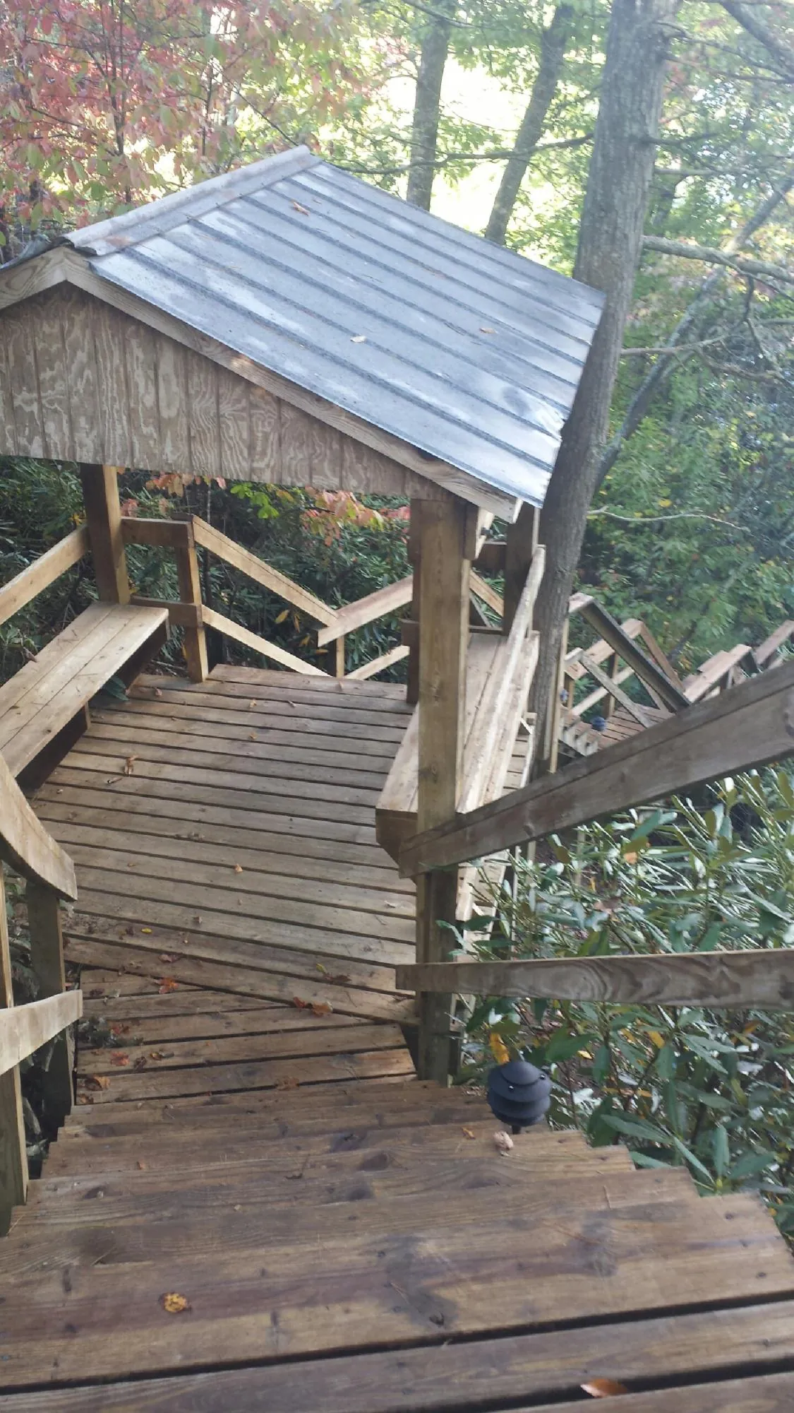 Metal roofed shelter over wooden steps on a wooded walkway — Skylight Repair & Installation work by our crew in Ickesburg