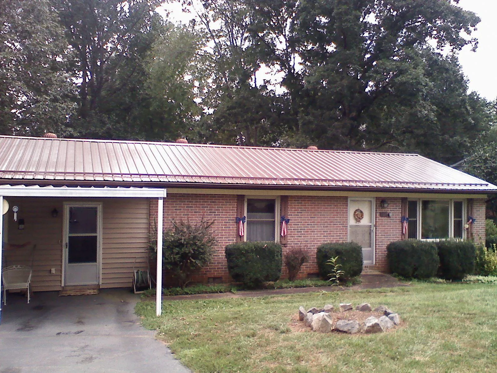 Bronze metal roof and carport on a brick ranch home — Roof Repair work by our crew in Ickesburg